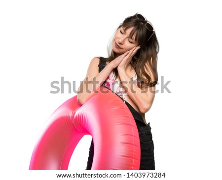 Young woman in bikini making sleep gesture in dorable expression over isolated white background