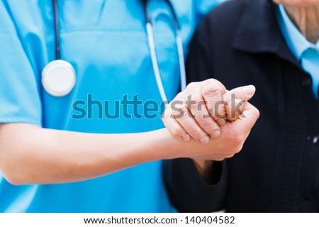 Caring nurse or doctor holding elderly lady's hand with care. Royalty-Free Stock Photo #140404582