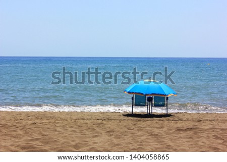 Beach umbrella and two chairs on a perfect beach to enjoy the holidays on a sunny day