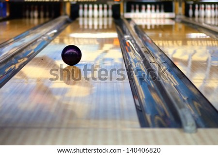 Swirling bowling ball is rolling down the path to the bowling pins
