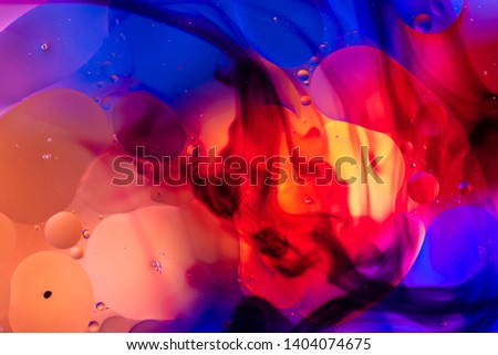 oily drops in water with colorful background, close-up  