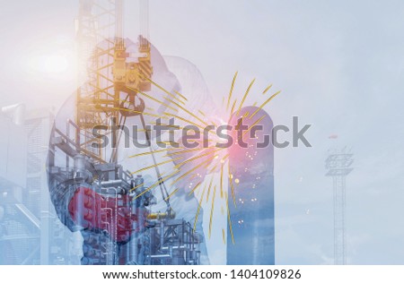 Double exposure Industry worker at the factory welding steel structure on Oil Refinery background.