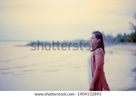 
The girl standing smiling by the sea