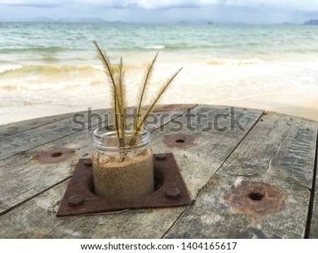 jar on wooden table at beach and clear water sea