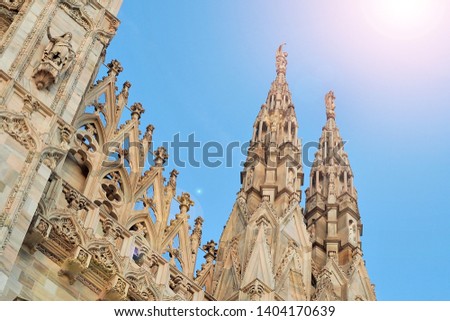 Duomo milan catheral top building in sunny time with sunlight ray on blue sky background