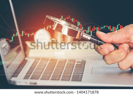 Hand hold magnifying glass for business technology for digital online investment with money graph