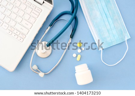 Stethoscope, laptop in the doctor's office.Top view of the doctor's Desk, a blank sheet of paper in a cage on a tablet with a pen. Form designer. Medicine concept.