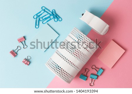 School and office stationery on a pink and blue background, top view