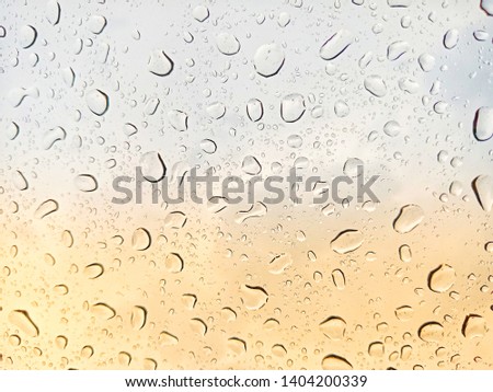 Raindrops on glass and blurred blue sky.