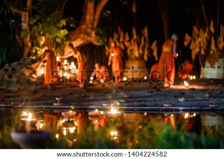 vintage style candle cup in Thai temple at night with monk background