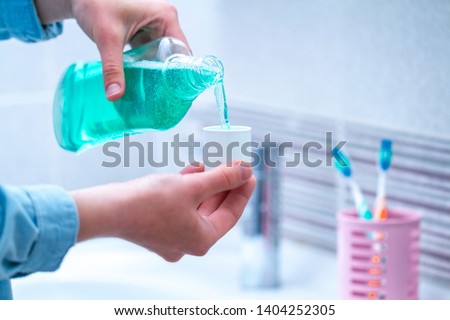 Oral hygiene, use of mouthwash for the health of teeth and gums. Fresh breath. Teeth care. Treatment of dental problems Royalty-Free Stock Photo #1404252305