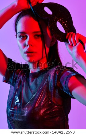 A woman in a transparent vest party disco purple background iridescent color on her face                        