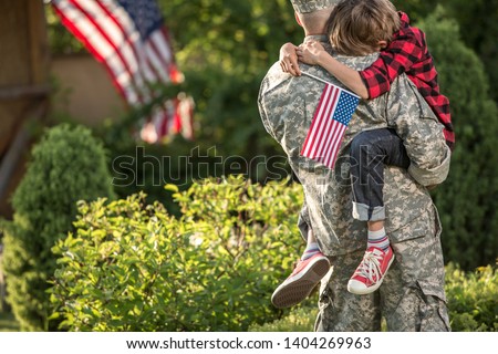 Happy reunion of soldier with family outdoors. Father with his son hugging, holiday, homecoming, emotions, happiness