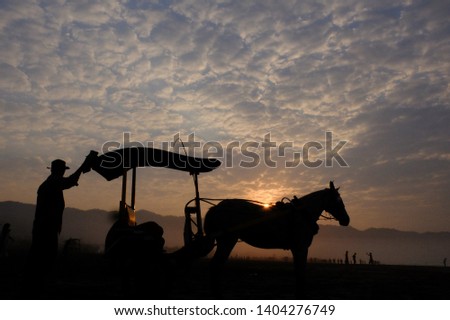 the silhouette of a horse-drawn rider and the dawn cloud. this picture is suitable for wallpaper or background.