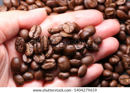 Coffee bean close up macro photo of look delicious dark roasted coffee beans, Flash light reflecting on the surface of the coffee beans make it look shinny beautiful and be nice for eat.