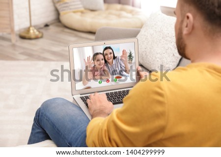 Closeup view of man talking with family members via video chat at home