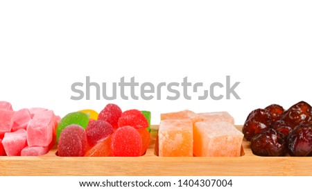 Wooden plate with cashew, marmalade and sweet turkish delight. Isolated on white background. Space for text or design. 