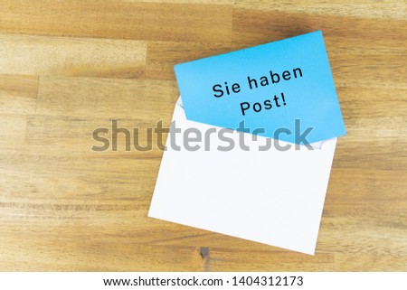 Envelope with a blue note with the german words for you have mail