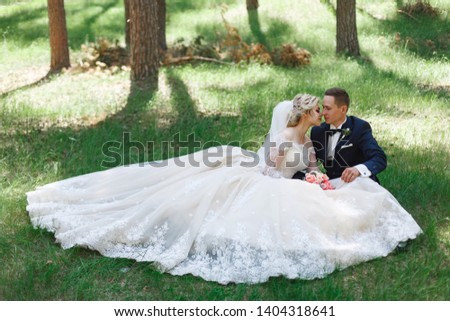 emotional wedding couple in green park in spring. portrait of bride and groom in sunny day outdoors. bride and groom hugging and smiling at the wedding day in nature. Beautiful newlyweds walk outdoors