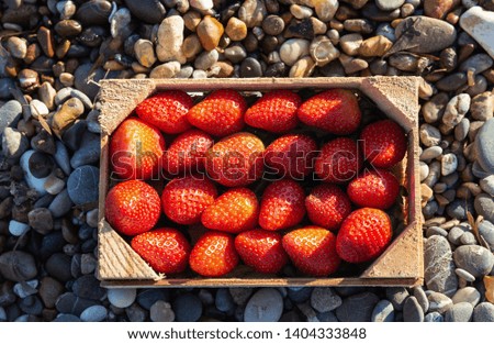A box full of ripe strawberries on stone background. Organic food concept
