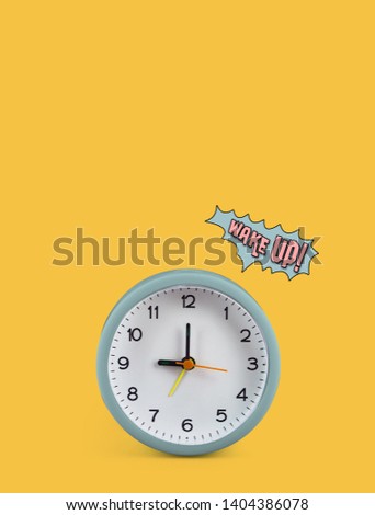Green alarm clock on yellow background, At nine o'clock in the morning, At three o'clock at night, The short needle is at the nine numbers and the needle is twelve numbers. Have the word wake up