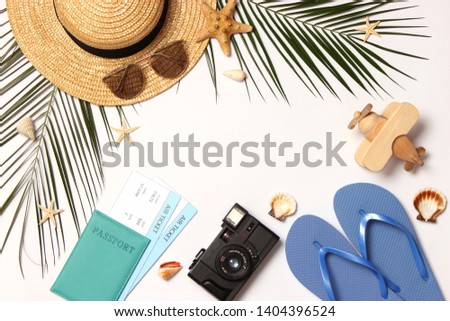 accessories for travel and tropical leaves on a light background top view.
