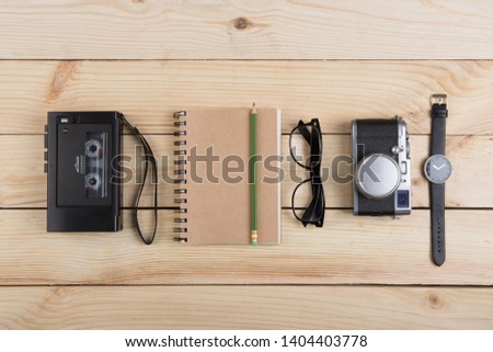 Writer, journalist or traveler desk - tape recorder, notepad and photo camera on the wooden background