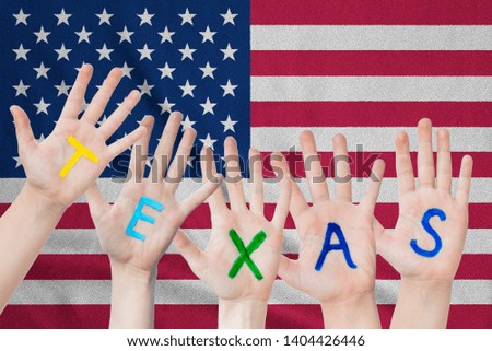 Inscription Texas on the children's hands against the background of a waving flag of the USA