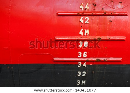 Red ship hull with waterline and draft scale measure Royalty-Free Stock Photo #140451079
