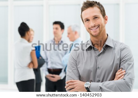 Portrait Of Young Handsome Businessman Smiling In Office Royalty-Free Stock Photo #140452903