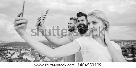 Group of young people standing in a row, outdoors, making a selfie.