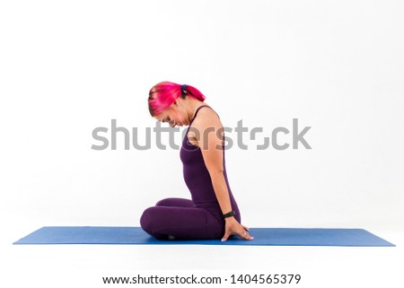 Sporty girl with pink hair sitting in yoga pose