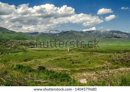  Mountain village Teghenik in Kotayk region of Armenia on the background of mountains and the spring sky with Cumulus clouds


