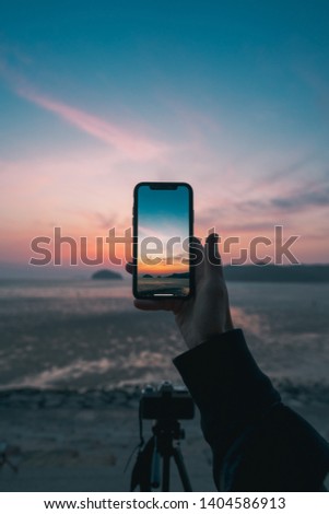 the photo of sunset on a mobile screen 