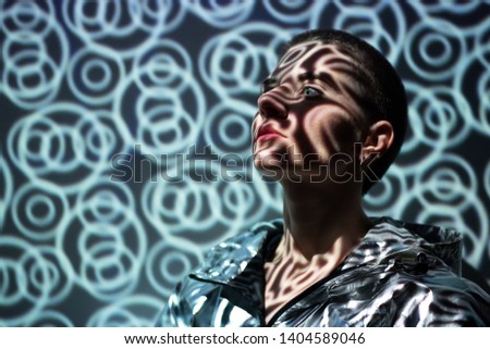 Portrait of young beautiful woman with reflection of light on her face, touchdesigner on background.