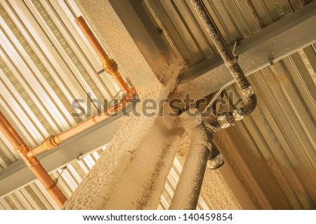 exposed underside of steel floor or roof deck with utilities and spray-on fireproofing Royalty-Free Stock Photo #140459854