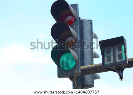 glowing green traffic light. green light on a street light. one second remains to turn yellow and red on the traffic light.