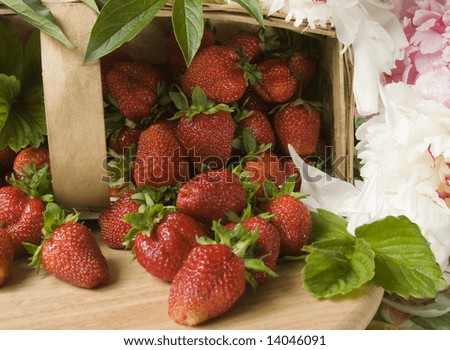 Basket of freshly picked strawberries with peony