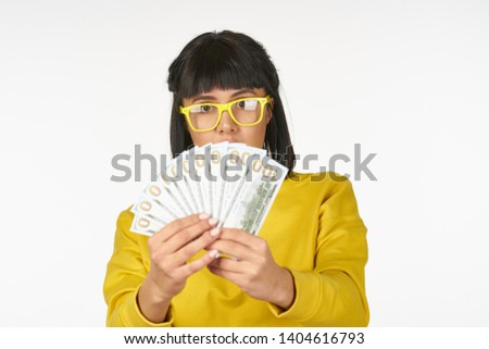  woman with glasses looking at money on an isolated background                             