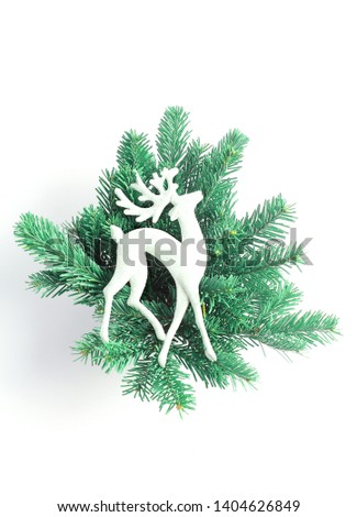 Beautiful Christmas composition on a white background. decorative toy deer in the branches of spruce. Flat lay, minimal layout