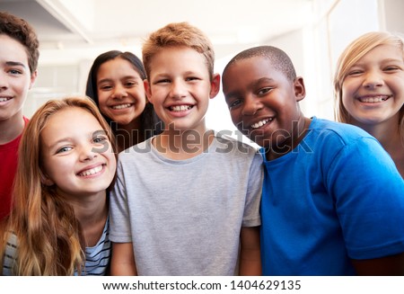 Portrait Of Smiling Male And Female Students In Grade School Classroom Royalty-Free Stock Photo #1404629135