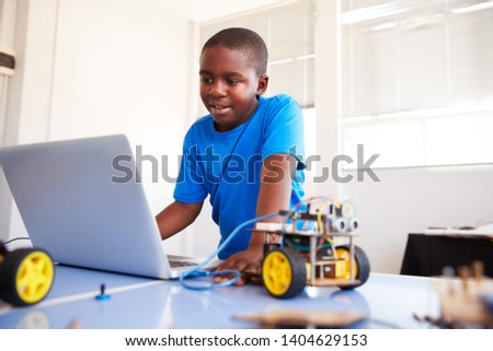 Male Student Building And Programing Robot Vehicle In After School Computer Coding Class Royalty-Free Stock Photo #1404629153