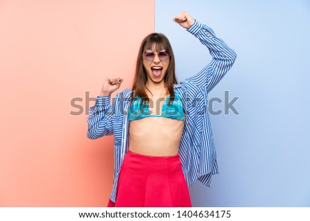 Young woman in bikini celebrating a victory in winner position