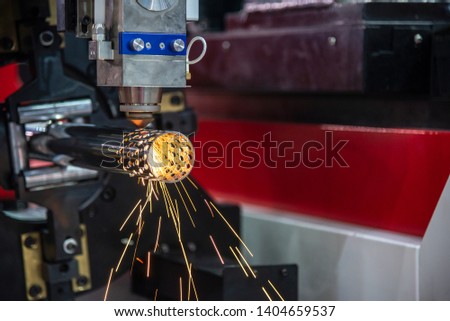 The fiber laser cutting machine cutting the stainless tube. The CNC fiber laser cutting with the flame light.