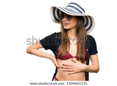 Young woman in bikini standing and looking to the side over isolated white background