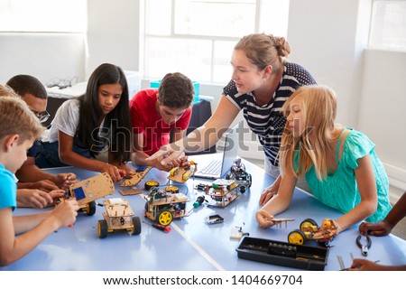 Students In After School Computer Coding Class Building And Learning To Program Robot Vehicle Royalty-Free Stock Photo #1404669704
