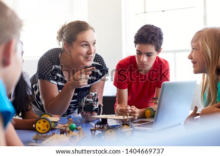 Students In After School Computer Coding Class Building And Learning To Program Robot Vehicle Royalty-Free Stock Photo #1404669737