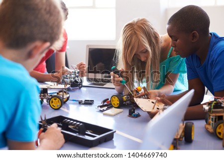 Students In After School Computer Coding Class Building And Learning To Program Robot Vehicle Royalty-Free Stock Photo #1404669740