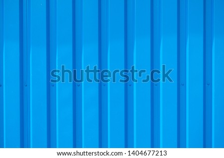 Close up photo of a facade from an industrial building with graphic stripes of minimalistic vertical blue metal profiles. Background image. 
