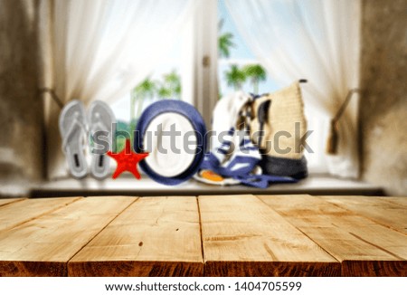 brown wooden table in home with blurred background of summer window with summer bag and hat and flip flops. Free space for your decoration. 